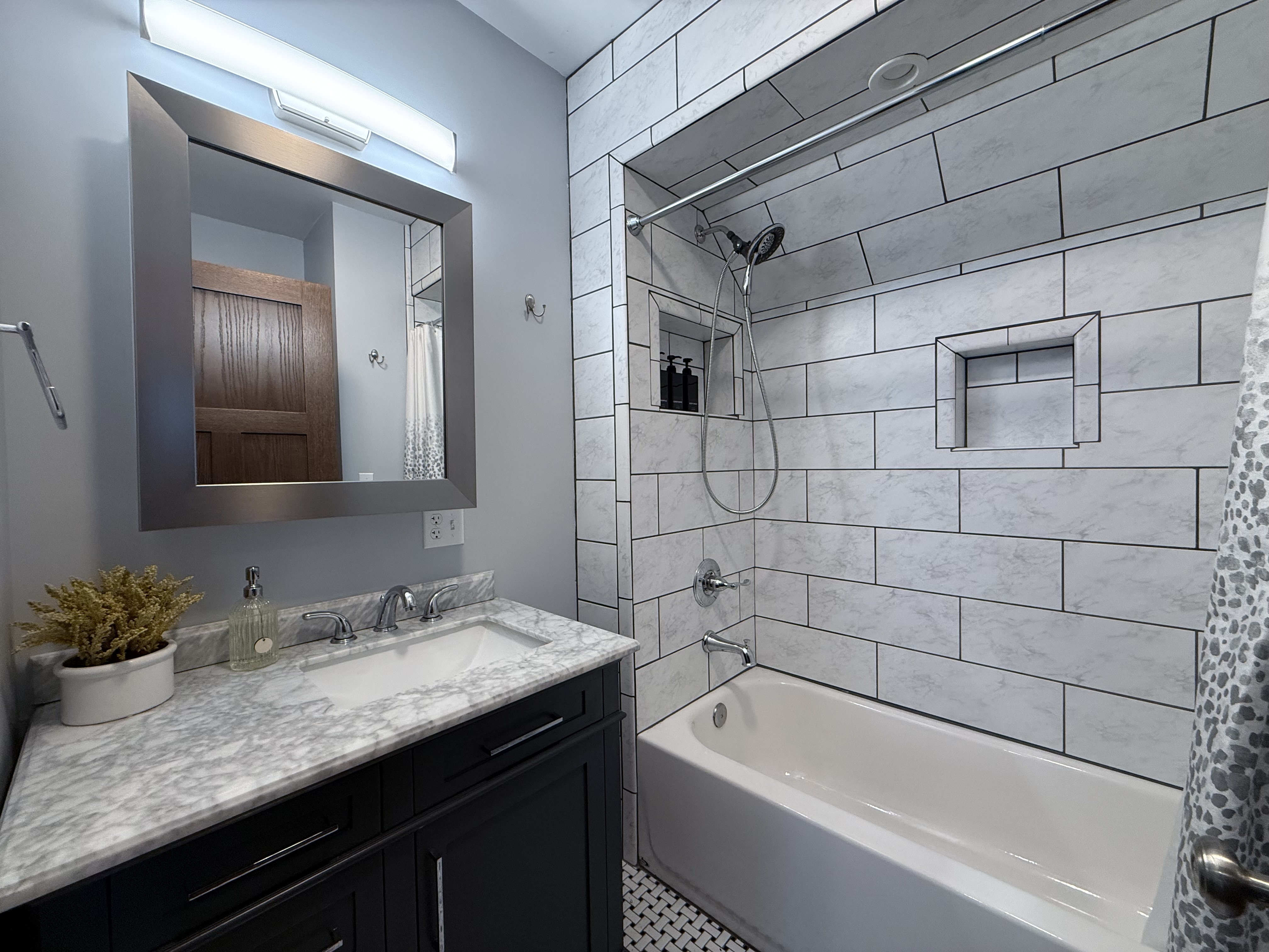 The Fifth — hall bath with marble tile surround and soaking tub