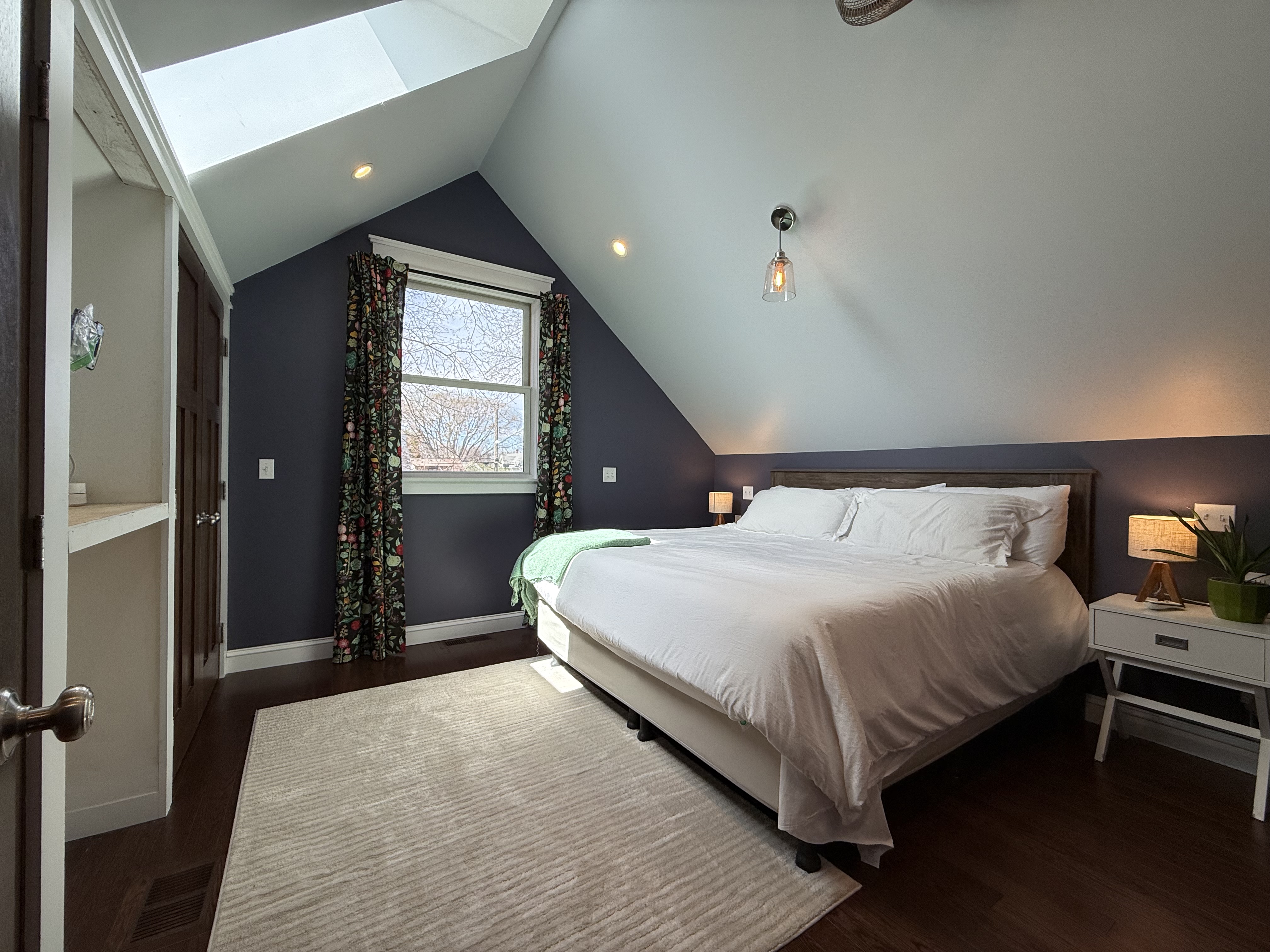 Third bedroom with navy accent wall and skylight