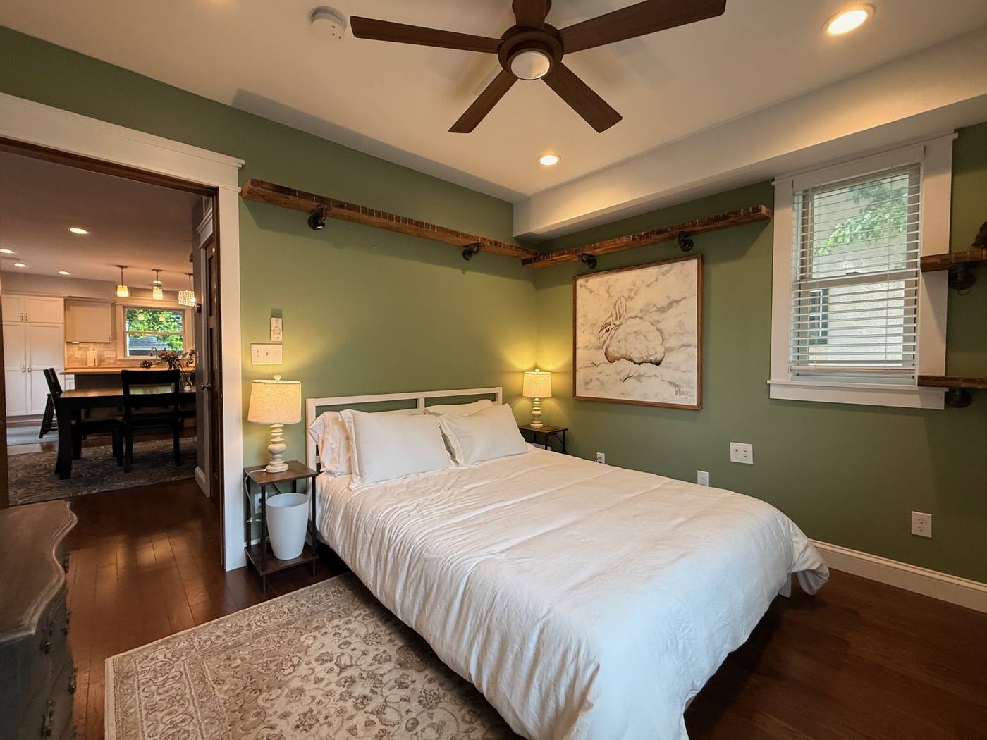 Main floor bedroom with sage green walls and natural light