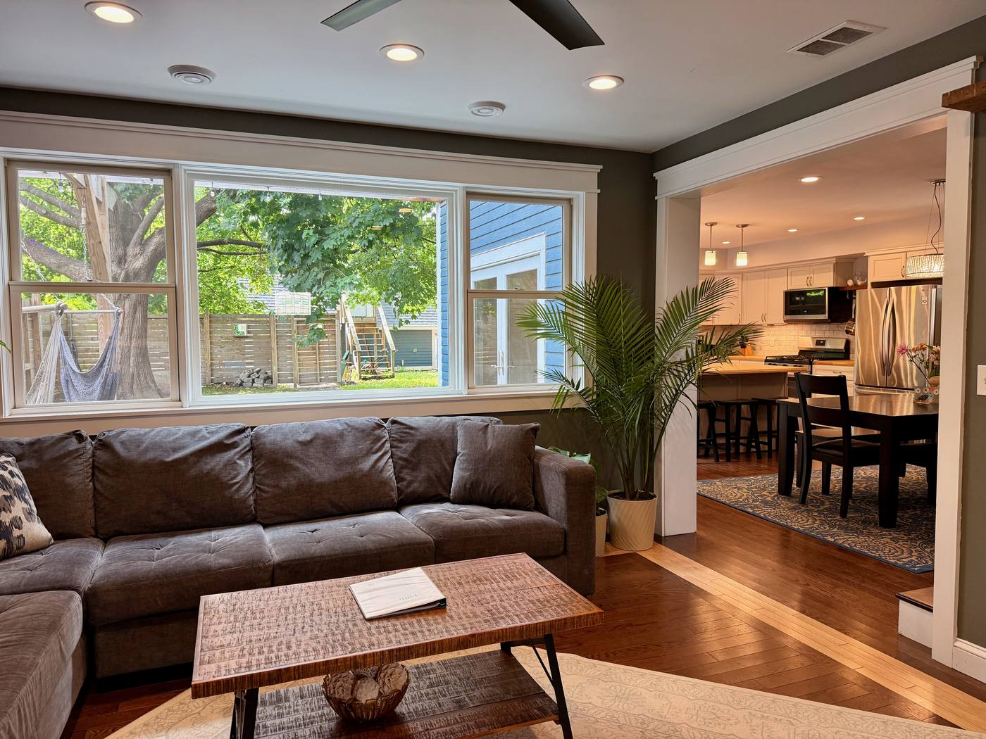 Living room with large windows and open view to kitchen
